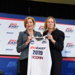 President Susan Herbst, left, and Val Ackerman, Big East commissioner, hold up a jersey marking the announcement of UConn's return to the Big East athletic conference on June 27, 2019. (Peter Morenus/UConn Photo)