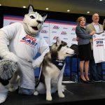 Jonathan the Husky, left, and Jonathan XIV pose for a photo, while President Susan Herbst, Joel Fisher of MSG, and Val Ackerman, commissioner of the Big East look on, following an event announcing UConn's return to the Big East athletic conference on June 27, 2019. (Peter Morenus/UConn Photo)