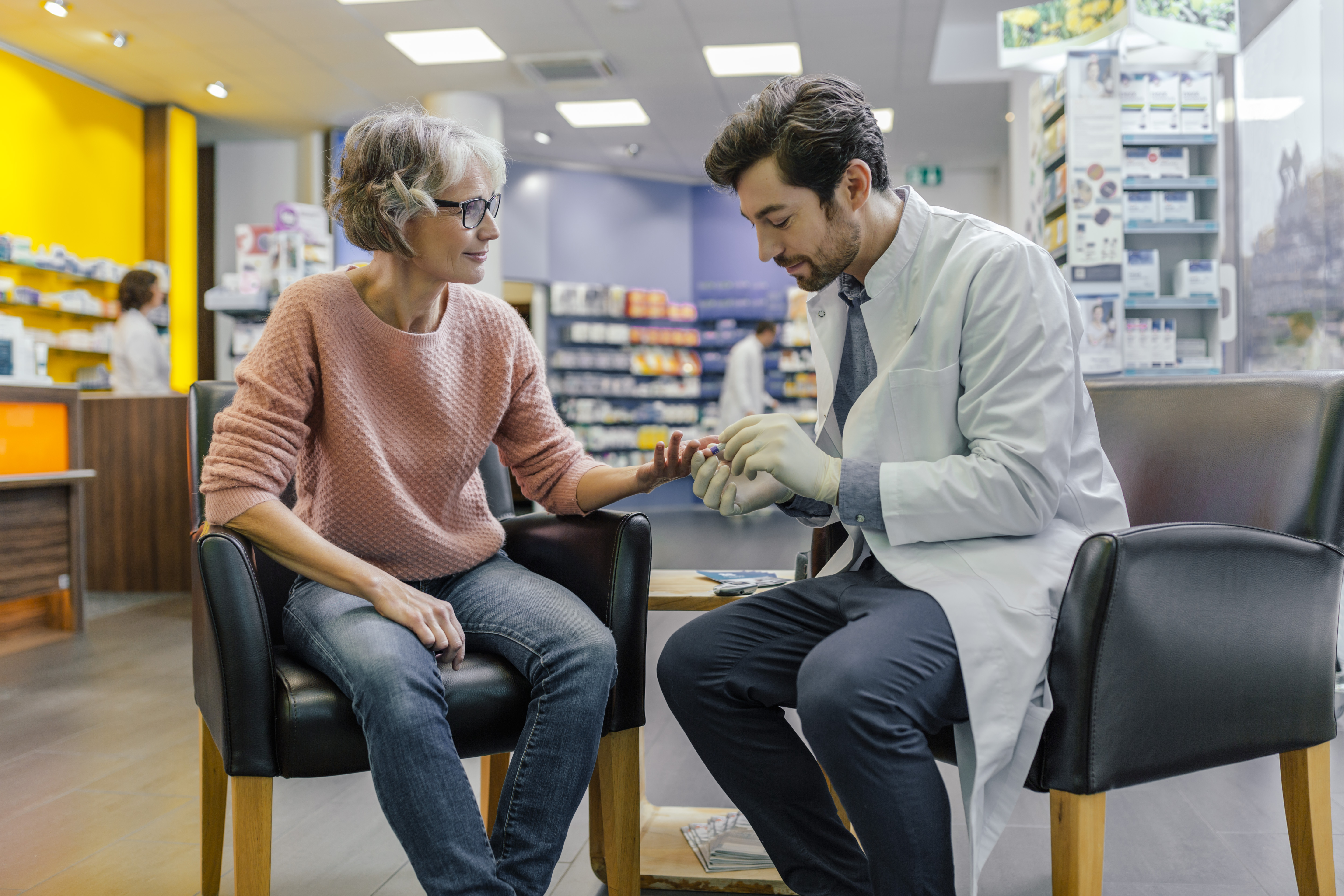 Pharmacist measuring blood sugar of customer in pharmacy. (Getty Images)