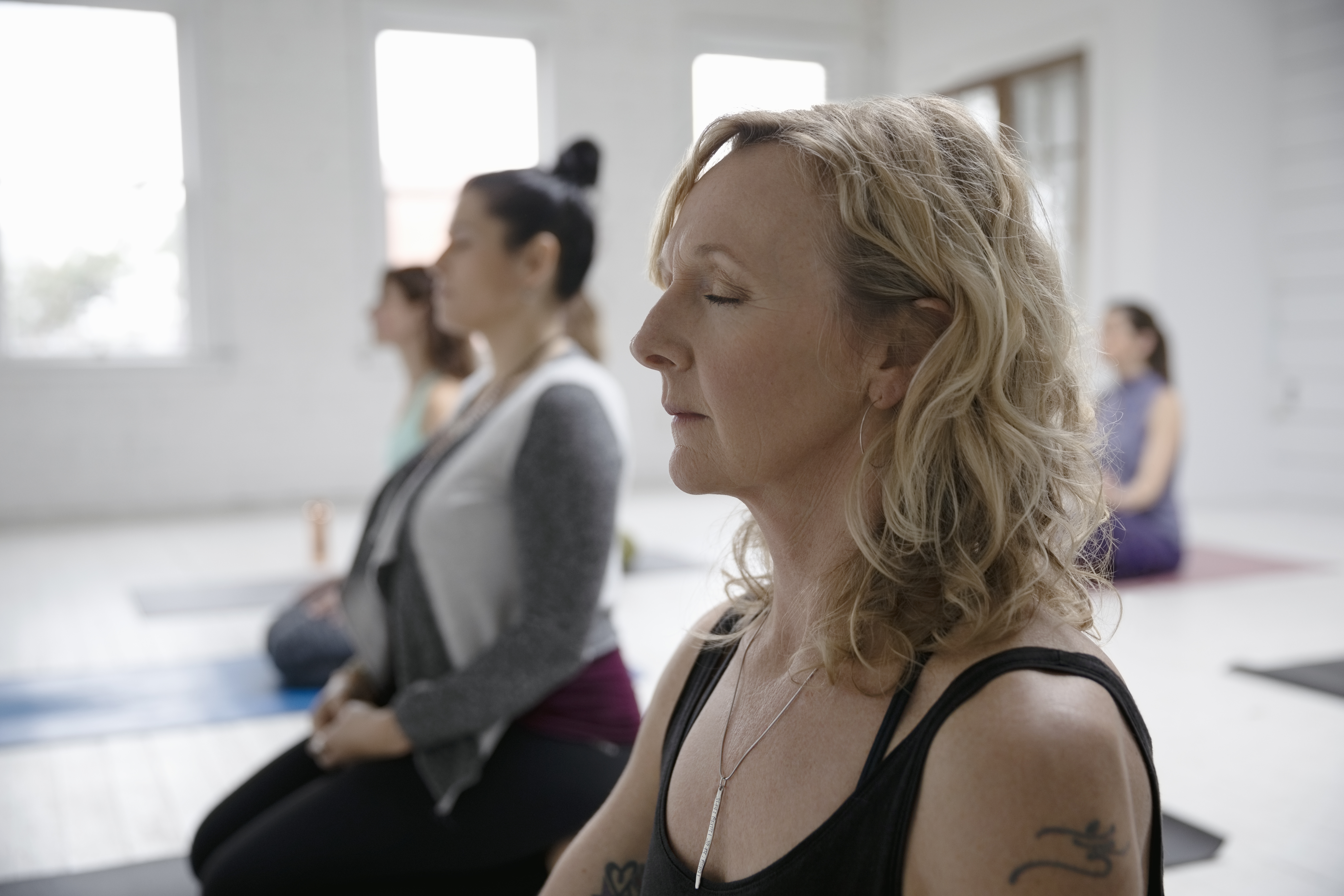 Serene woman meditating in yoga class. (Getty Images)