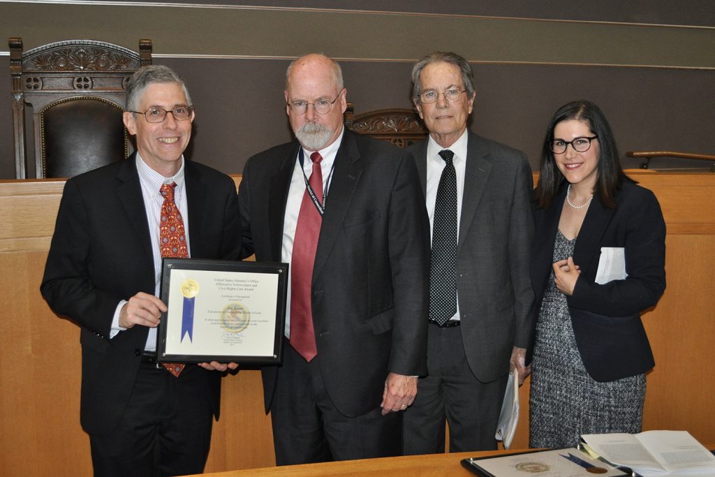 UConn Law Professor Jon Bauer, left, receives a 2019 Law Enforcement Award from John Durham '75 JD, the U.S. Attorney for the District of Connecticut with John Hughes, chief of the Civil Division of the U.S. Attorney’s Office for the District of Connecticut, and Assistant United States Attorney Jessica Soufer '11 JD of the office’s Affirmative Enforcement and Civil Rights Unit.