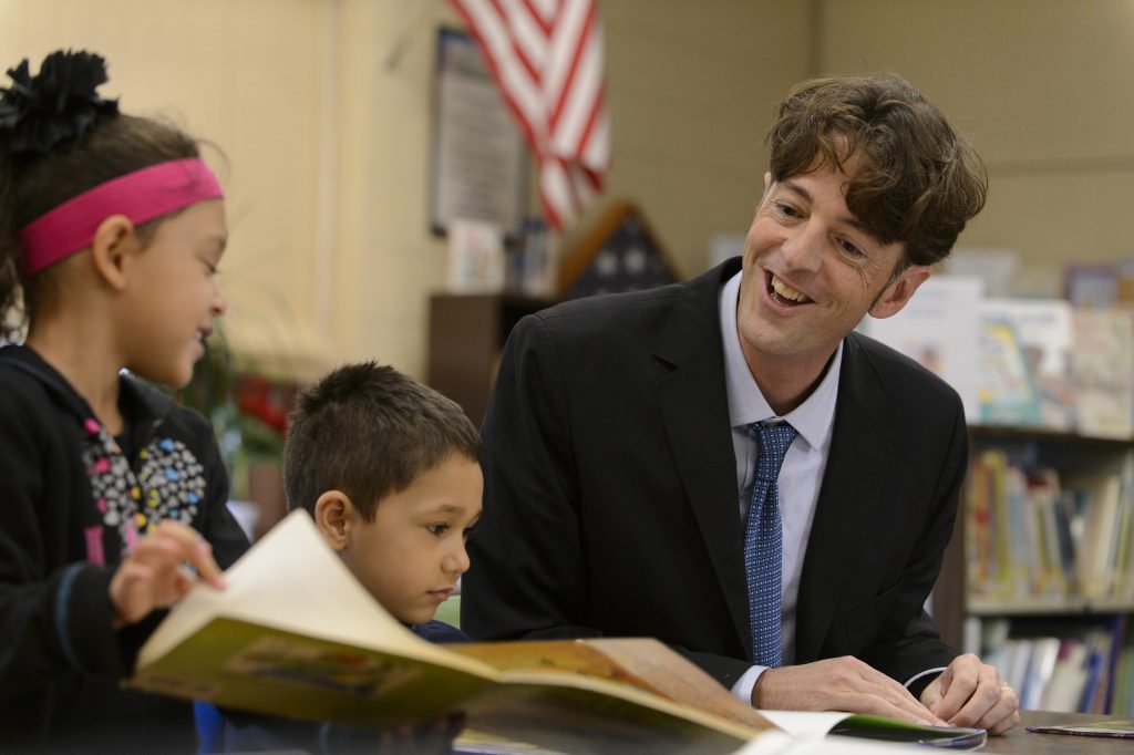 Michael Coyne reads with elementary school children.