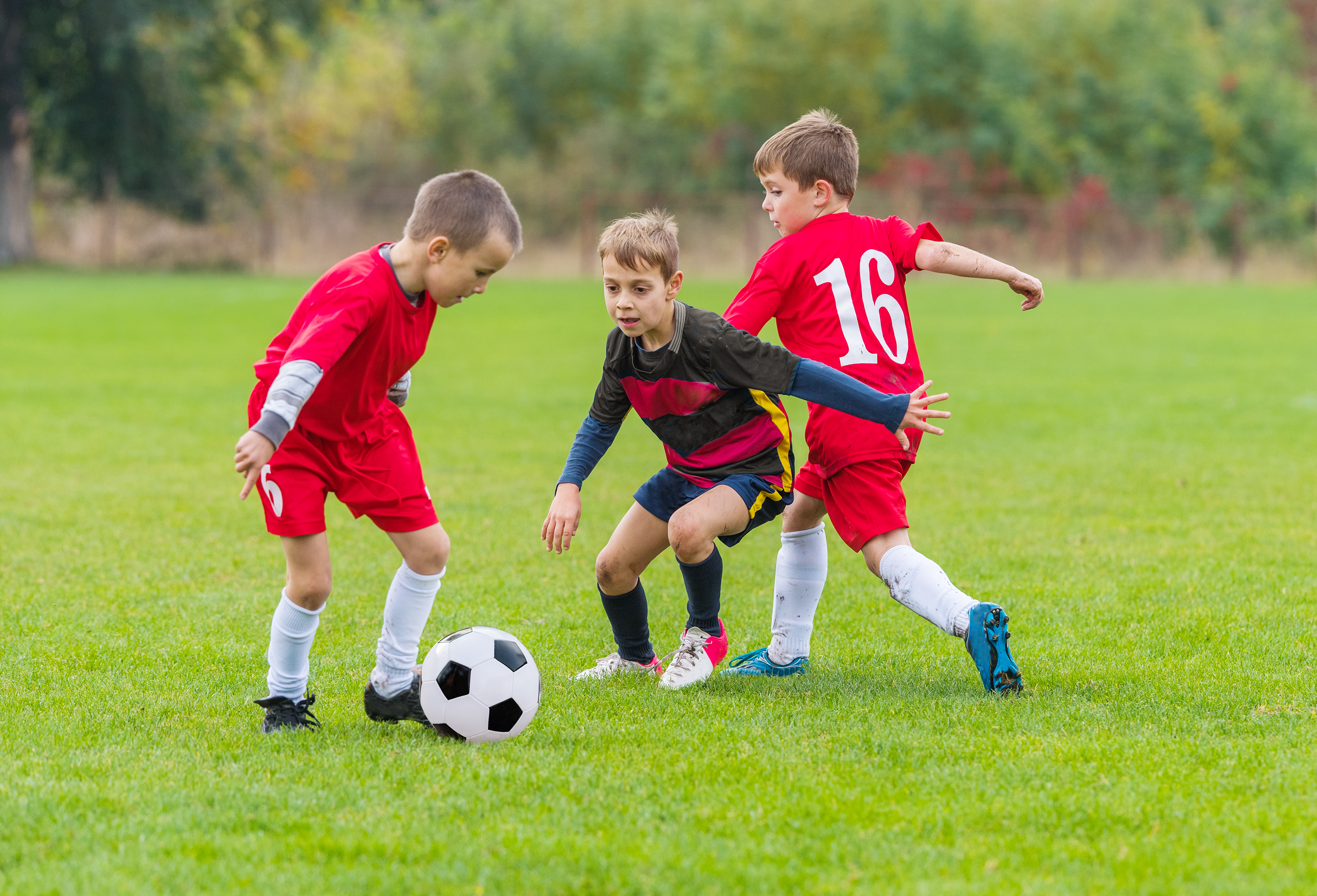 Boys kicking soccer ball on the sports field. (Getty Images)