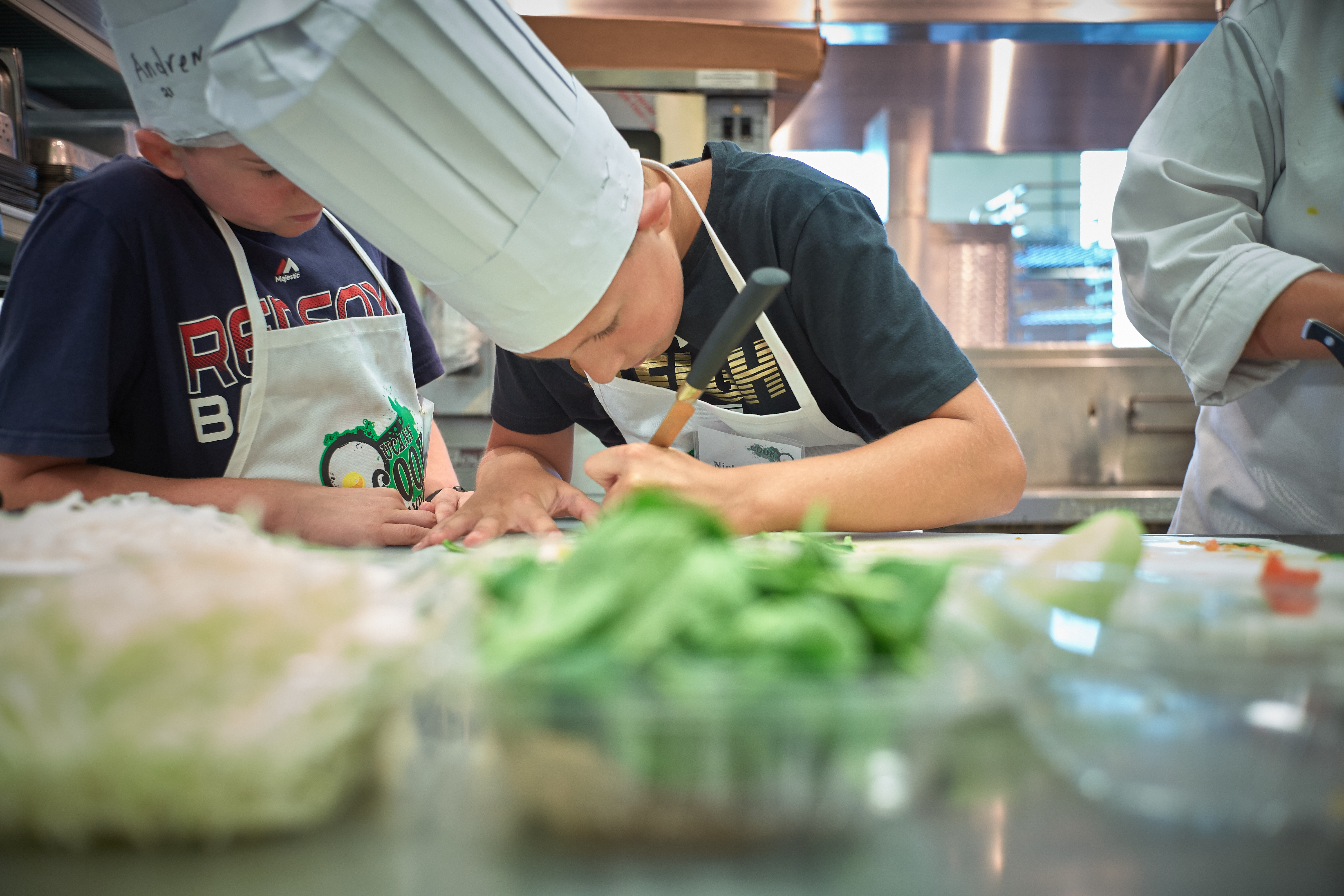 Nick Wigfield, 12, of Baltic, slices cucumbers for a garnish during a competition at the UCann Cook Camp at Gelfenbien Commons on July 18, 2019. (Peter Morenus/UConn Photo)