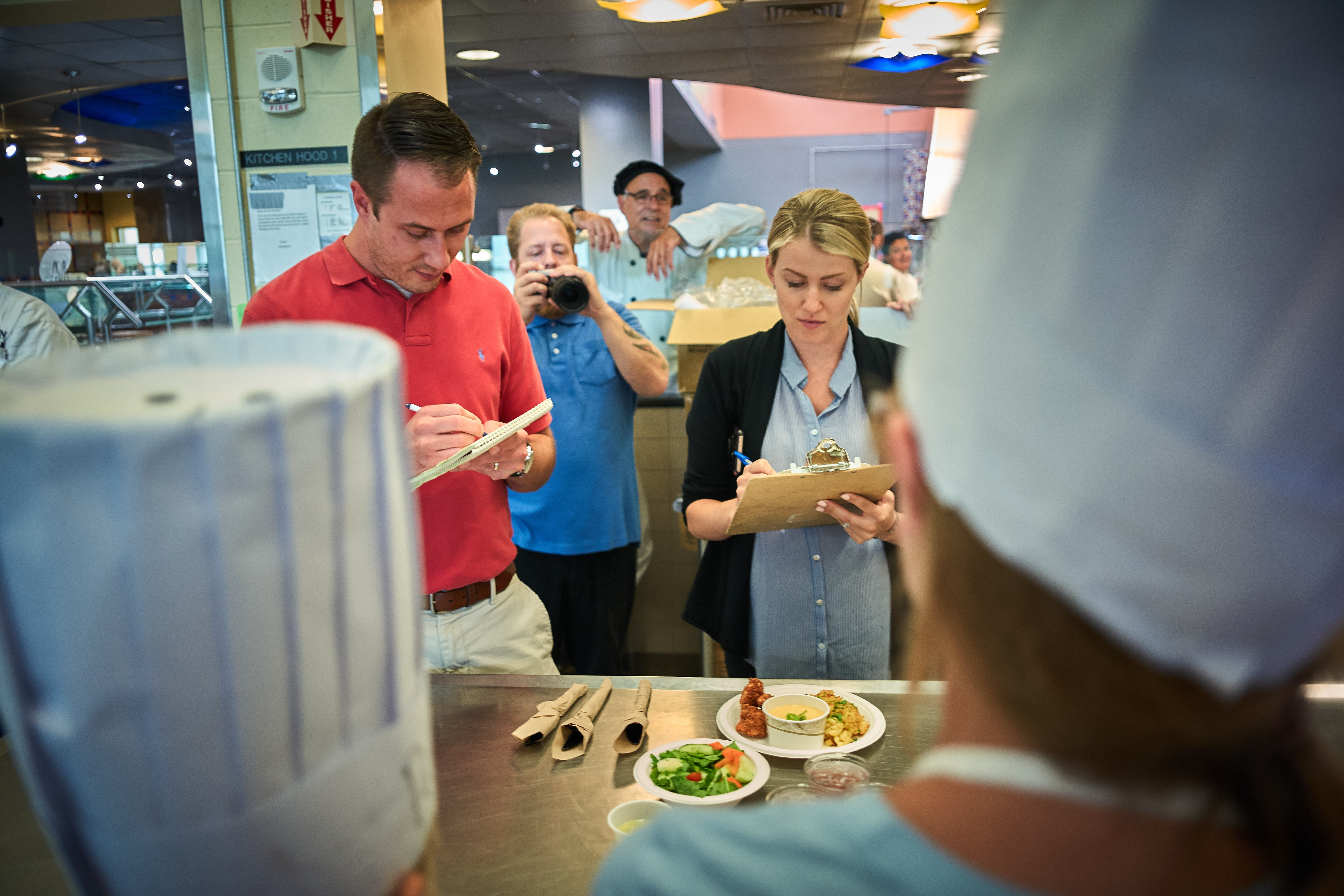 Alex Morley, left, and Jen Steszewski, both of the dining services business office, grade an entry during a competition at the UCann Cook Camp at Gelfenbien Commons on July 18, 2019. (Peter Morenus/UConn Photo)