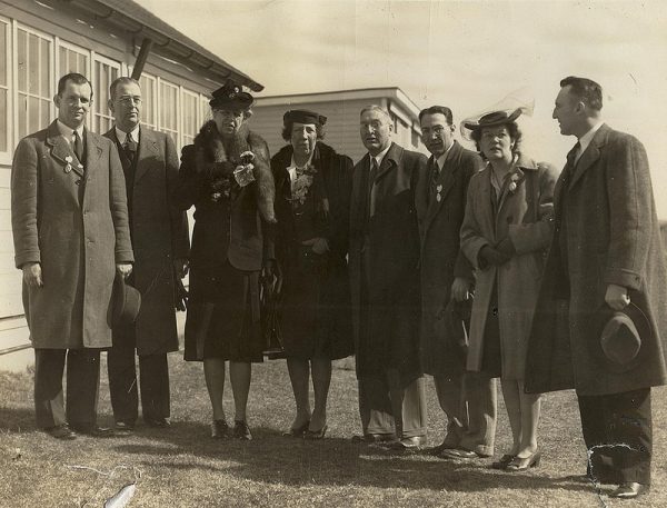 Members of the UConn administration with First Lady Eleanor Roosevelt in 1943. To the left of Roosevelt is President Albert Jorgensen. Second right from the First Lady is Edwin G. Woodward, dean of the College of Agriculture, and to his right is farm management professor Paul Putnam. The person standing at far right is assistant dean Wilfred B. Young. The other individuals are not identified. (University Library Archives &amp; Special Collections)