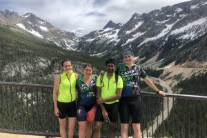 Liz, Keanna, Yoga and Justin at Washinton Pass, with snow-capped mountains in teh background. 