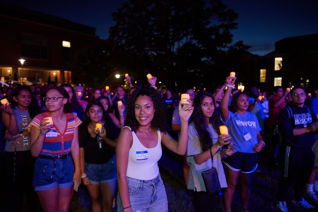 Students hold electric candles during the Convocation ceremony on the Student Union Mall. (Peter Morenus/UConn Photo)