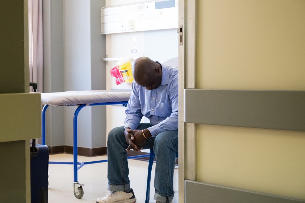 An African American male waits for doctors. (Getty Images)