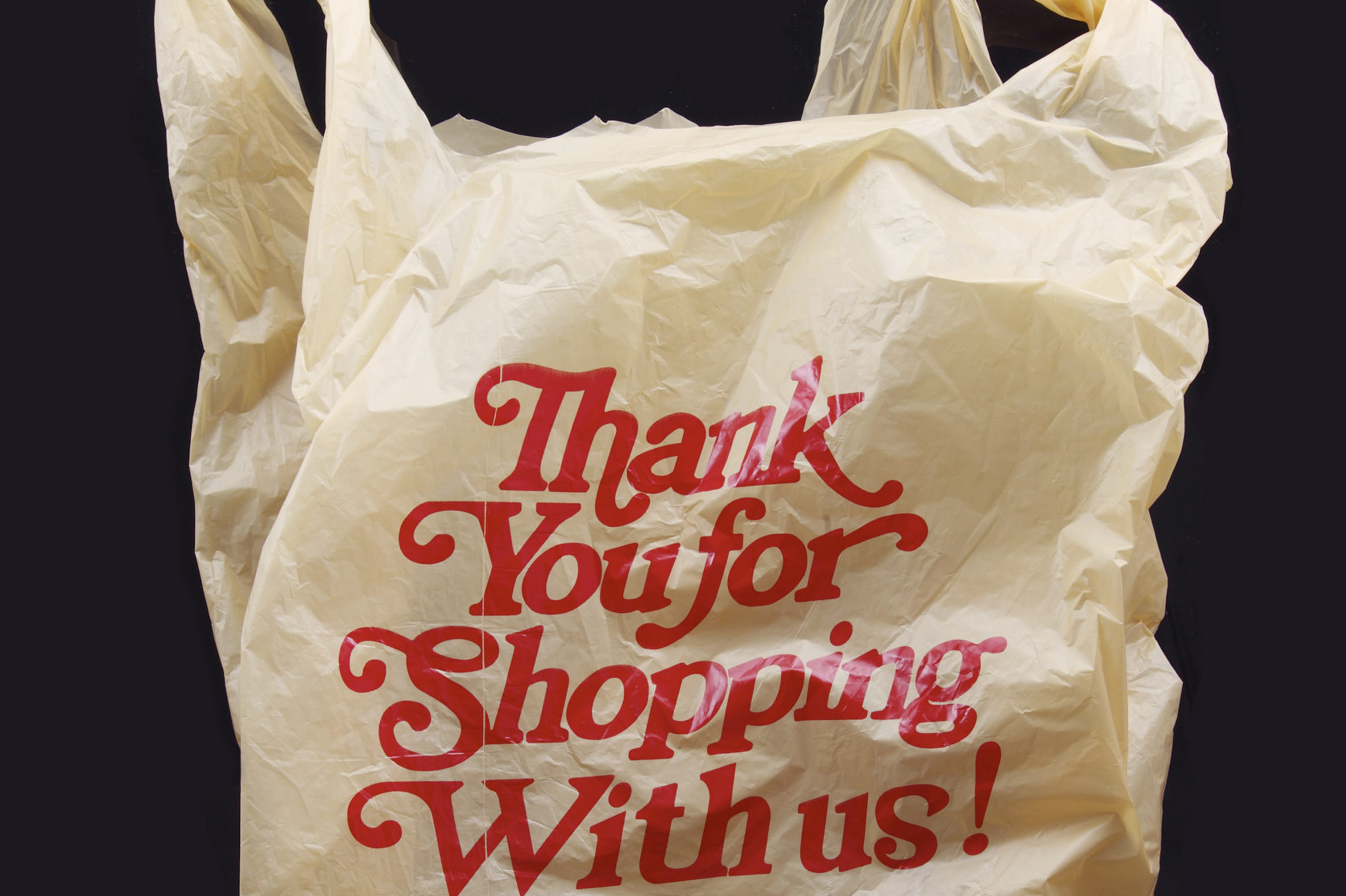 A plastic shopping bag floating in mid-air reads "thank you for shopping with us" to symbolize customer service, hospitality, and gratitude.