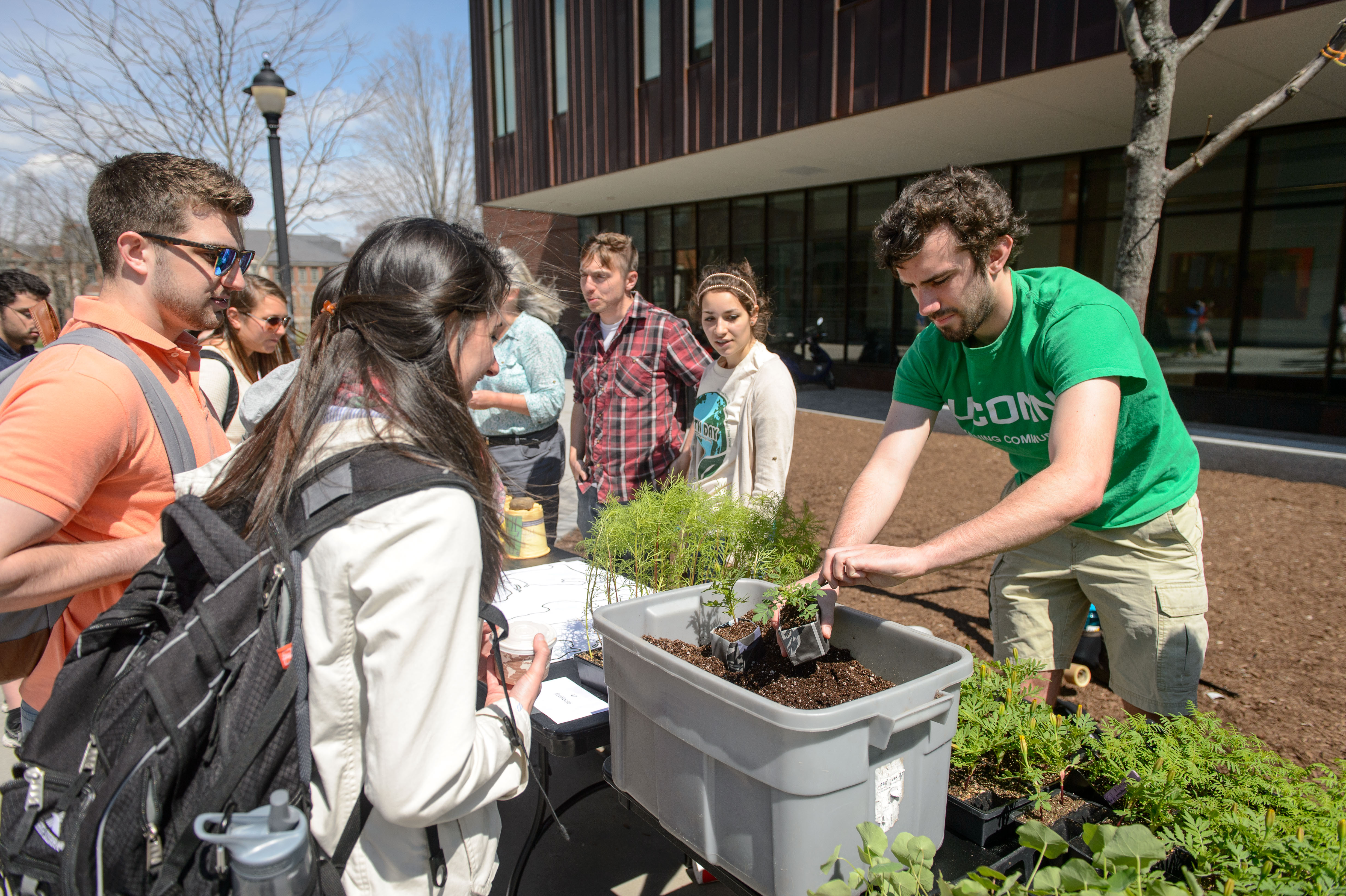 Students from EcoHouse and Spring Valley Farm hand out potted plants during one of the university's recent Earth Day celebrations. (Peter Morenus/UConn Photo)