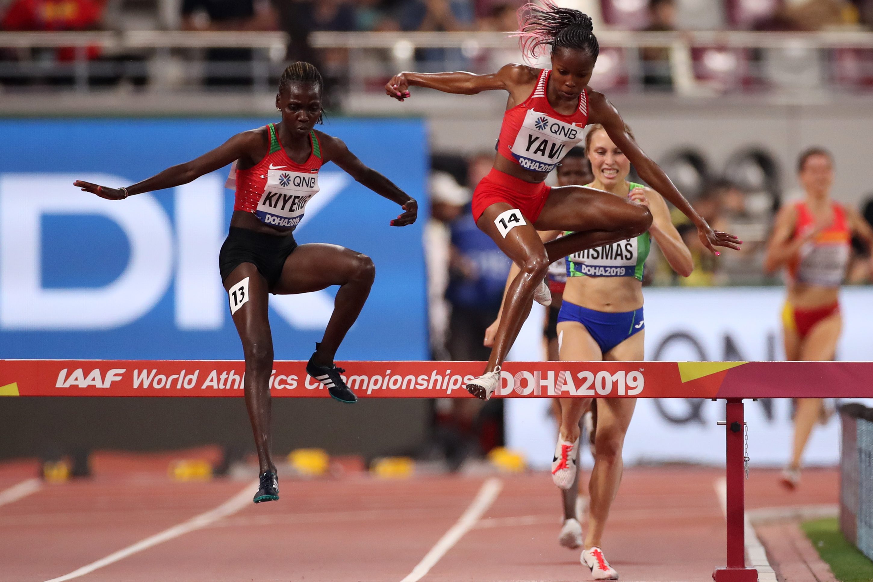 Winfred Mutile Yavi of Bahrain (C) and Hyvin Kiyeng of Kenya (L) compete in the Women's 3000 meter Steeplechase heats on Sept. 27, the first day of 17th IAAF World Athletics Championships in Doha, Qatar. (Christian Petersen/Getty Images)
