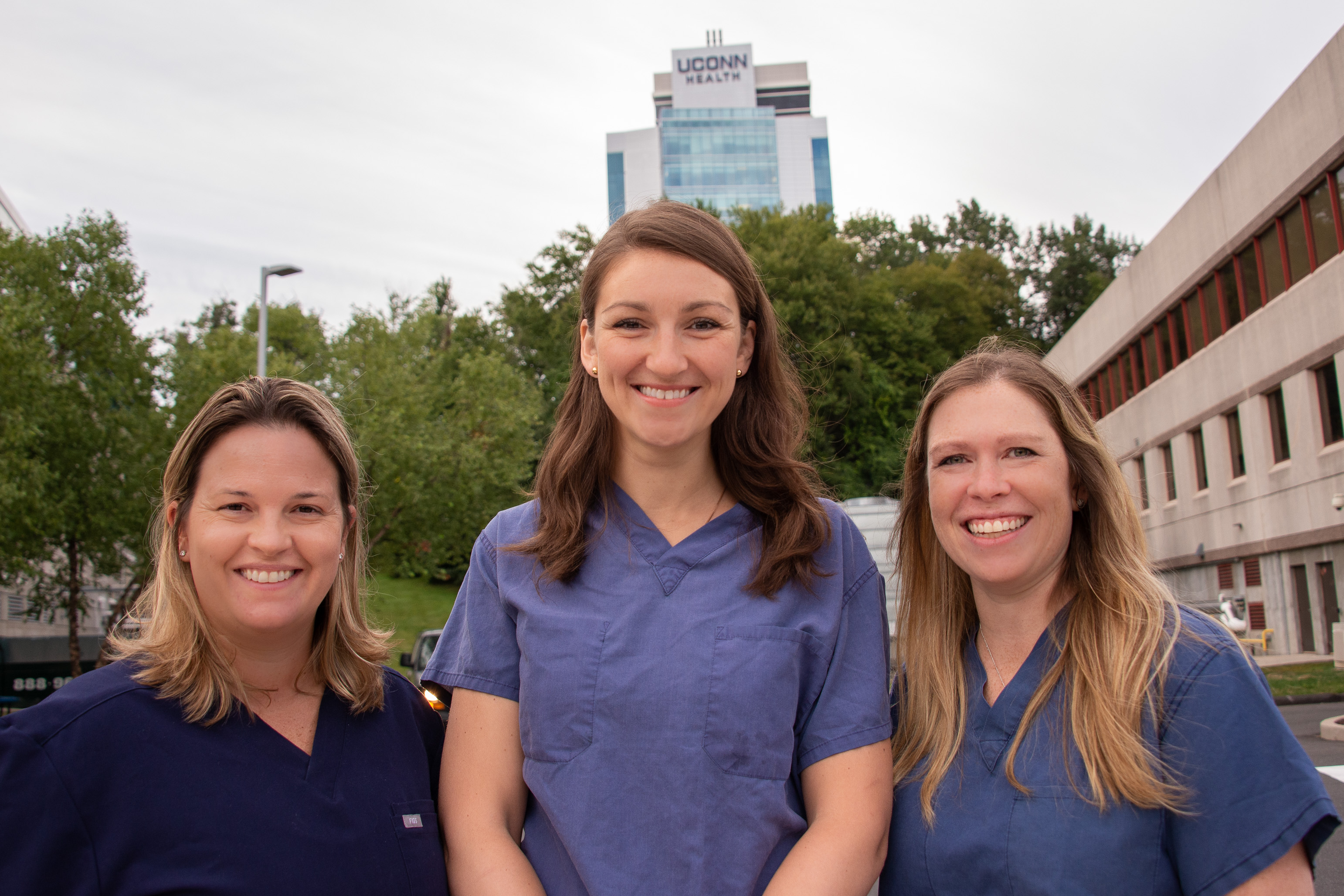 Drs. Kathy Coyner, Olga Solovyova, Lauren Geaney outside UConn Musculoskeletal Institute with University Tower in background