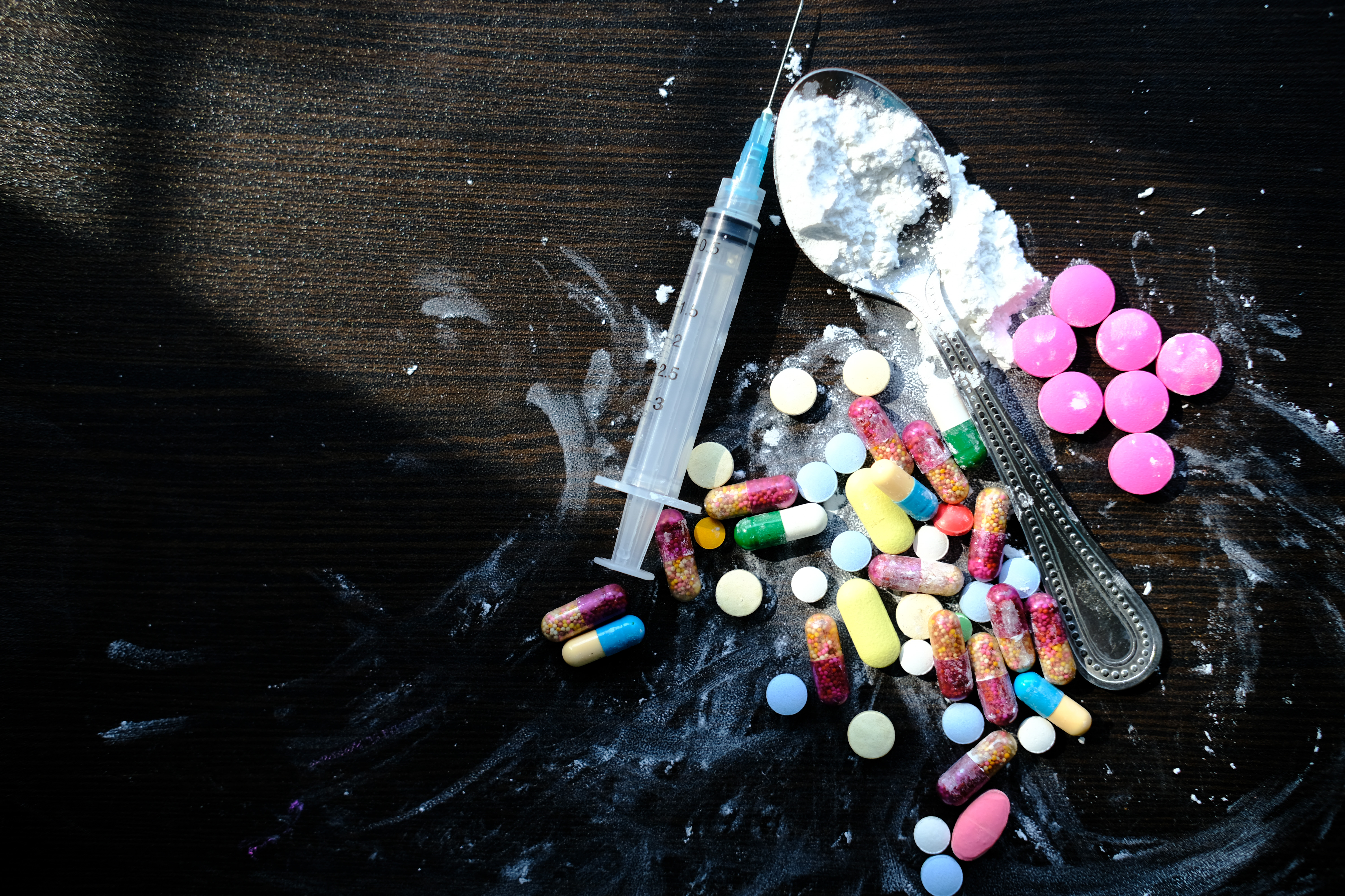 Drug, pill, syringes and heroin on wooden table, drug abuses