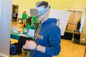A young man wears a VR headset as part of an innovation event