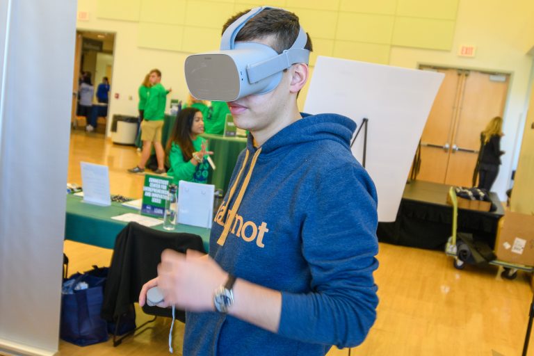 A young man wears a VR headset as part of an innovation event