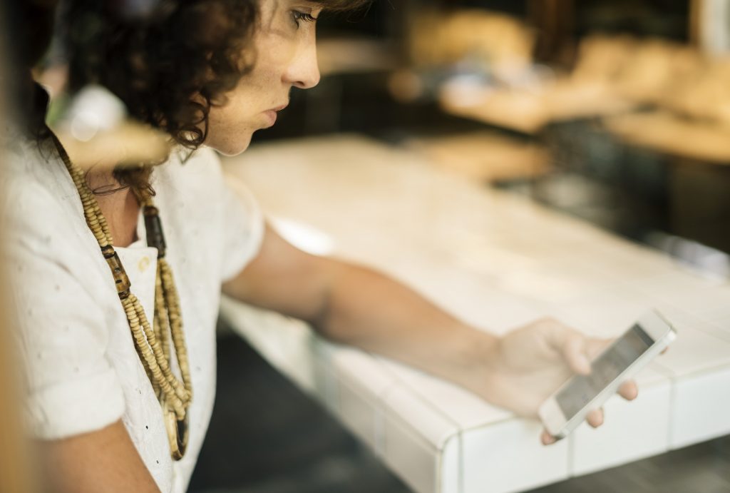 Young woman looks at iphone