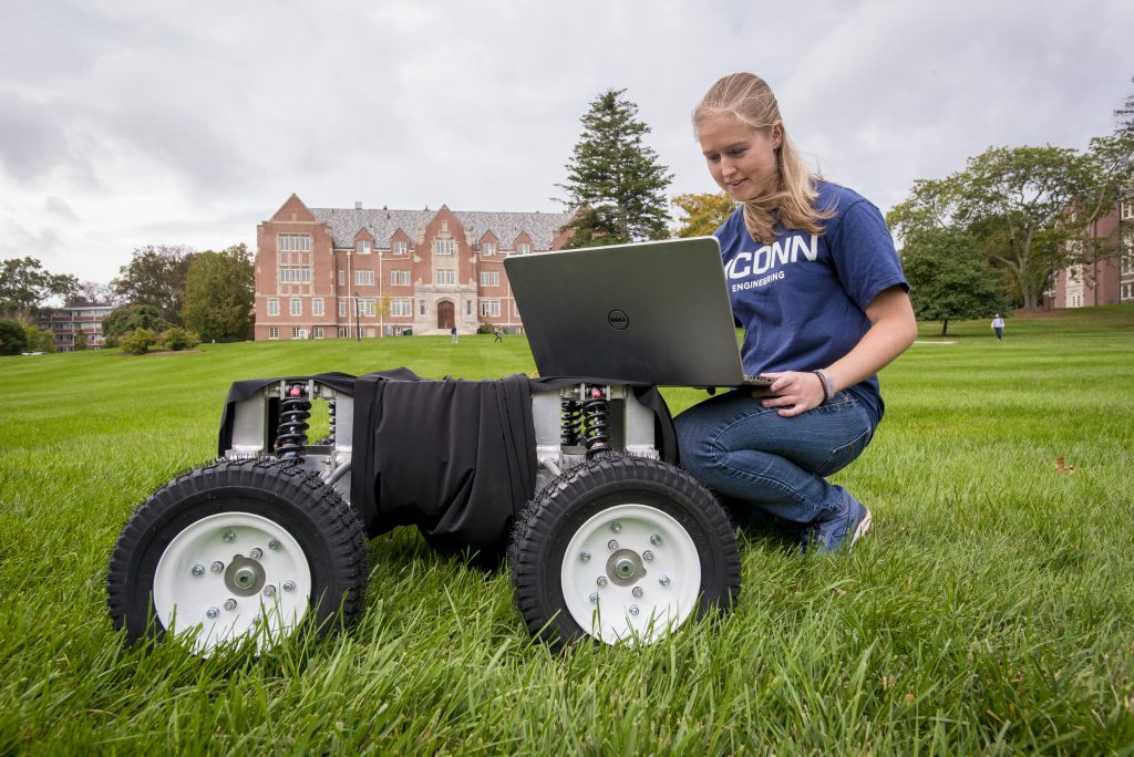 Emily Yale, one of the three inaugural students in the UConn Master's of Engineering in Global Entrepreneurship program, with her autonomous robot at the Great Lawn on Oct. 7. (Sean Flynn/UConn Photo)