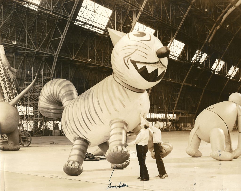 Workers inspect a giant balloon in the shape of a cat in an undated archival photo.
