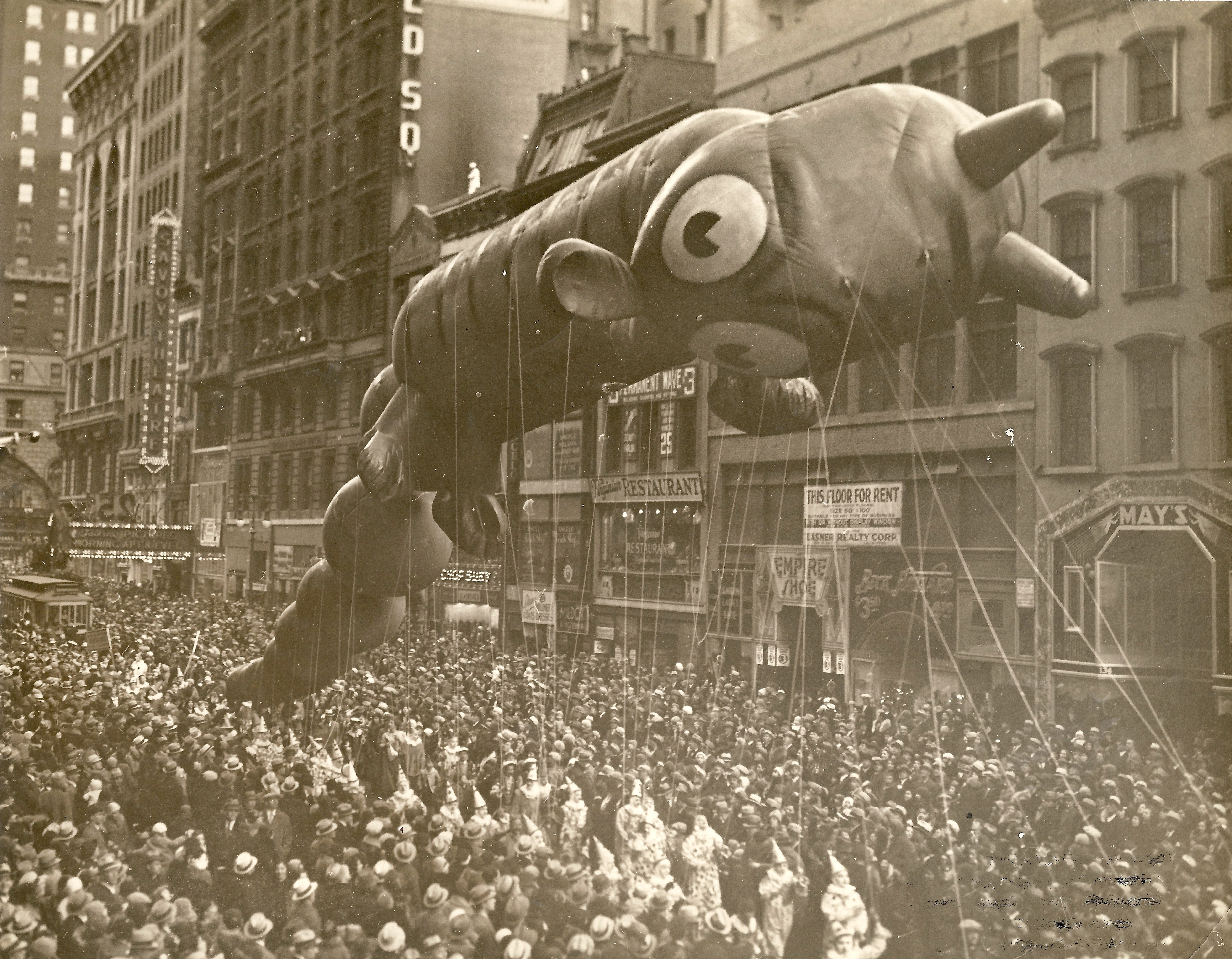 A black and white photo of a giant balloon in the Macy's Thanksgiving Day Parade in New York City