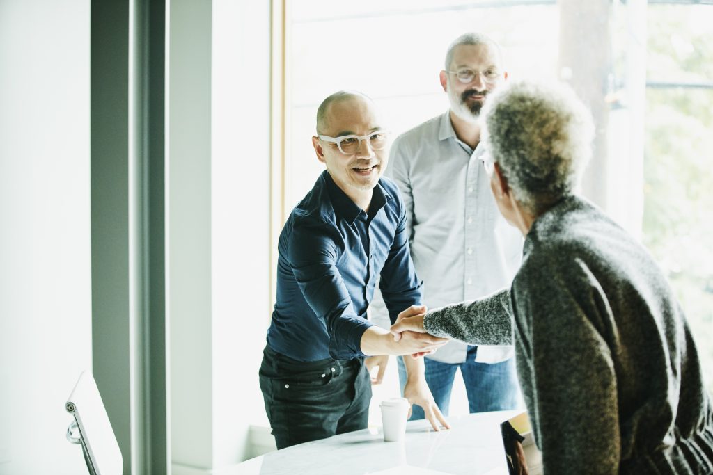 Businessman shaking hands with client before meeting in office conference room