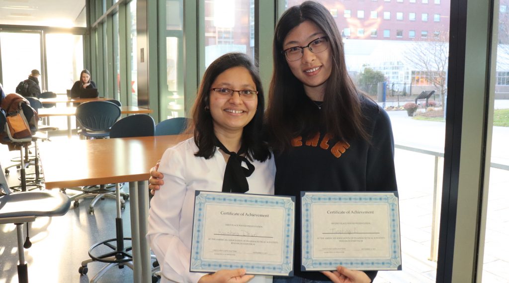 Two UConn Pharmacy students display their first and second place certificates from the 2019 AAPS Rearearch Symposium at URI