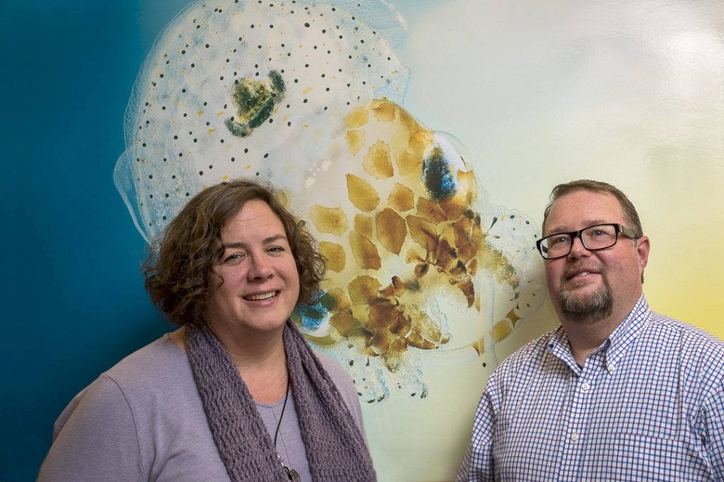 Researchers Marcy Balunas and Spencer Nyholm with a photo of a bobtail squid 