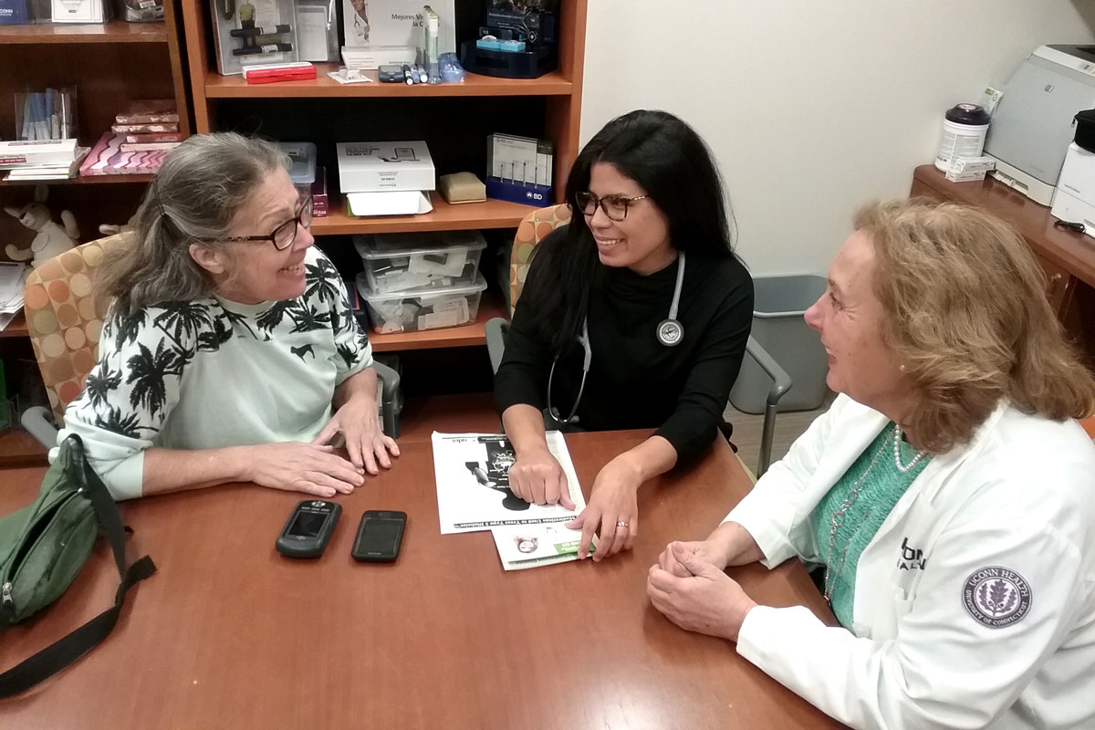 Diabetes patient speaking with some of her care team in a conference room