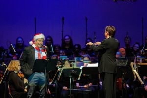 President Thomas Katsouleas, left, reads "A Visit from St. Nicholas" by Clement Clarke Moore while Keith Lockhart conducts the Boston Pops at the Jorgensen Center for the Performing Arts on Dec. 14, 2019. (Peter Morenus/UConn Photo)