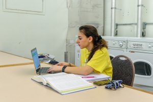 A student studies for a chemistry exam in the laundry room of a residence hall.