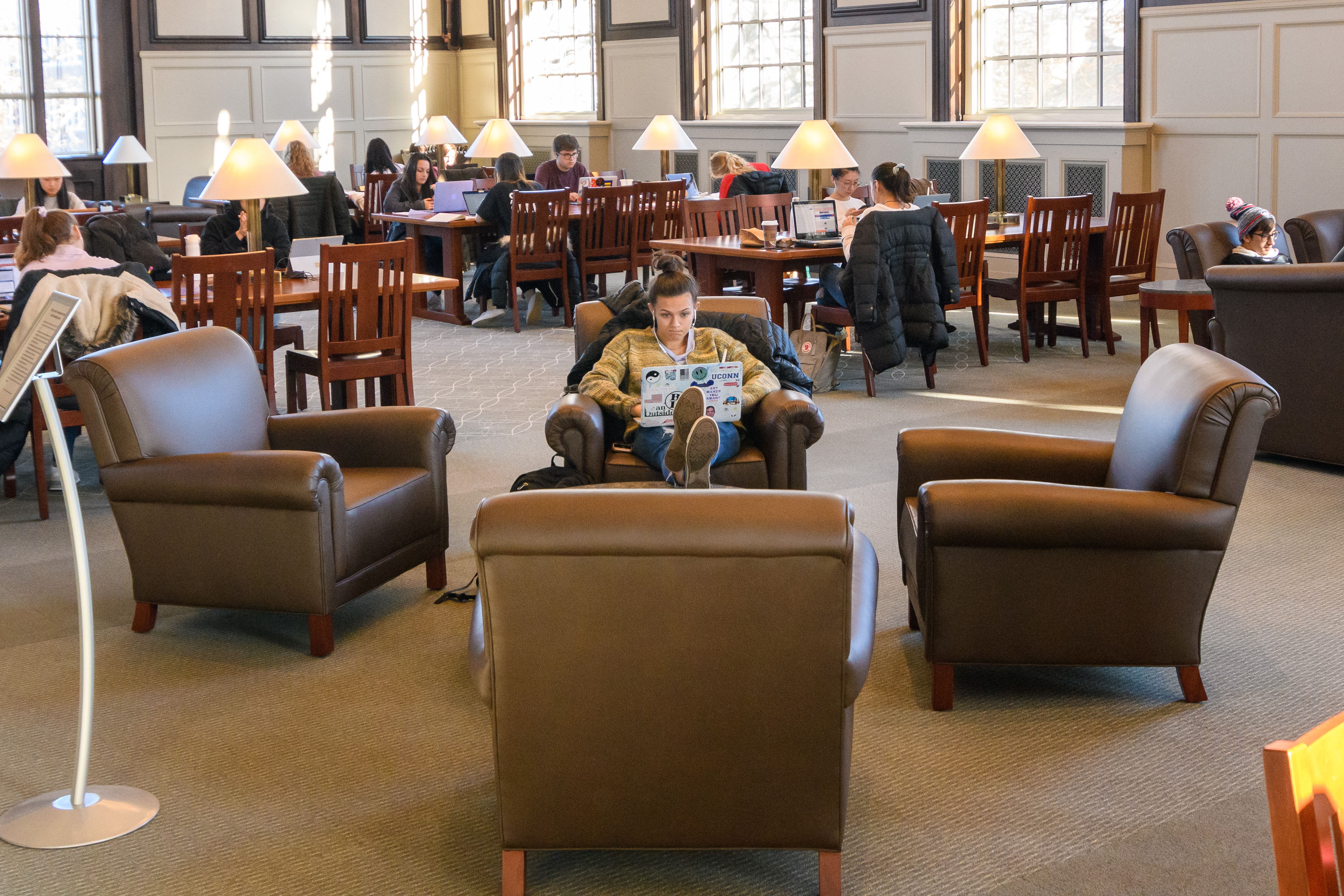 A student sits with her feet up while studying inthe Wilbur Cross South Reading Room.