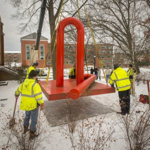 Workers are careful to gently place the huge sculpture on the ground. (Sean Flynn/UConn Photo)