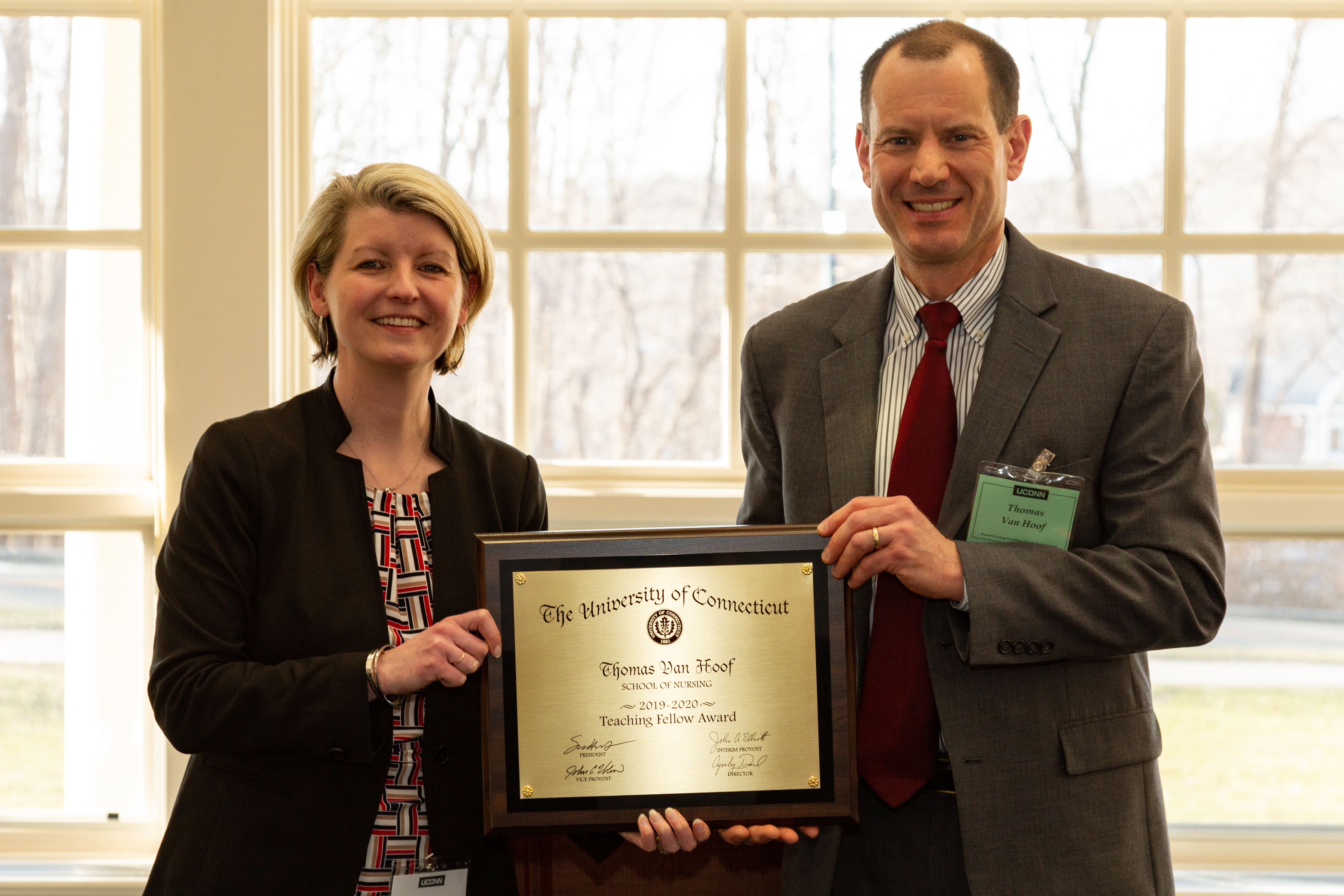 Anysley Diamond and Thomas Van Hoof hold an plaque honoring Van Hoof as a Center for Excellence in Teaching 2019-2020 University Teaching Fellow