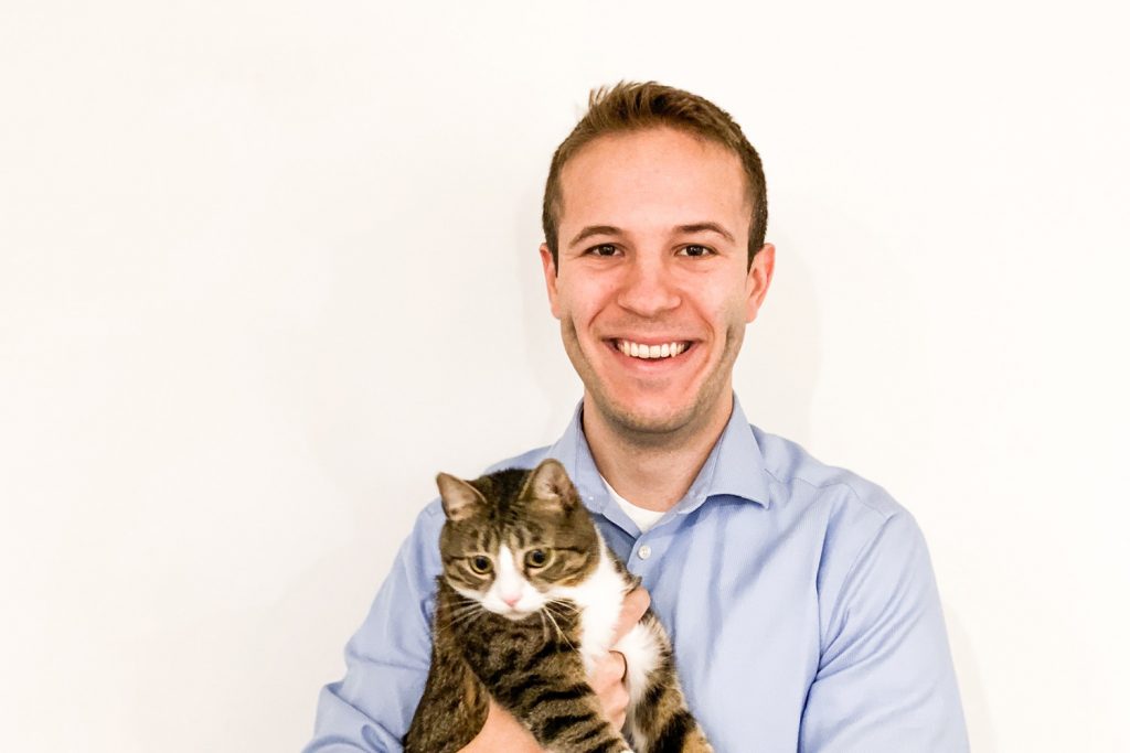 Travis Bloom poses with his cat, Ginny