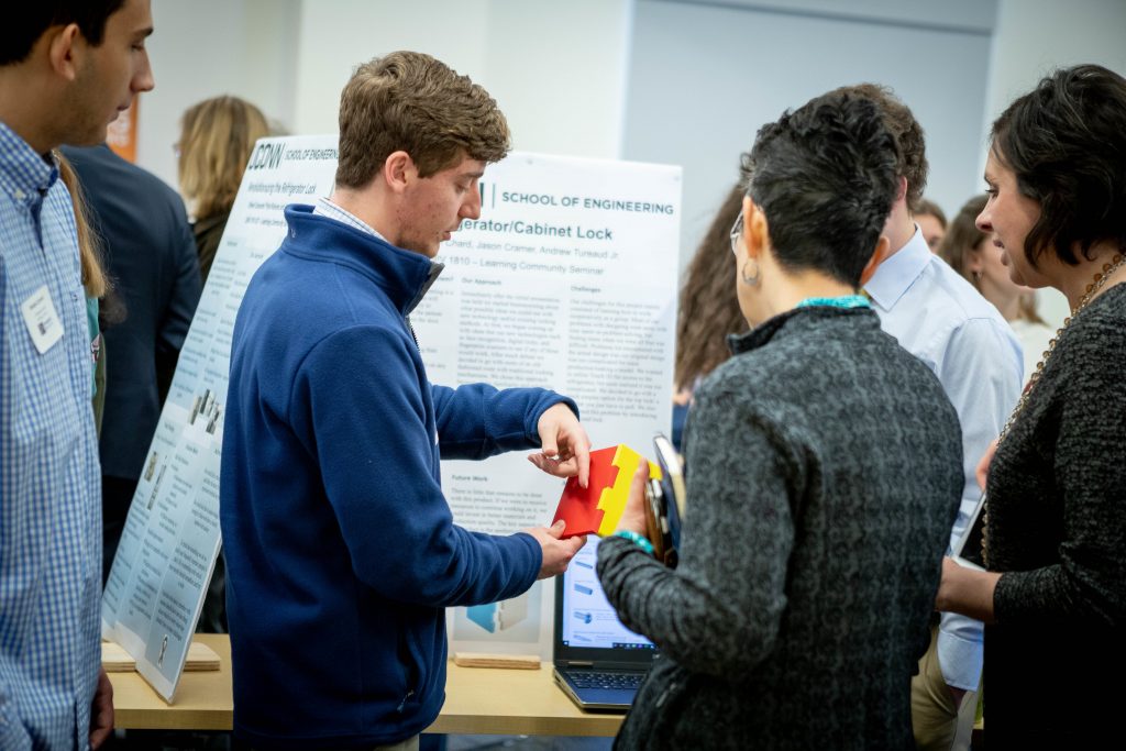 UConn Engineering students showcase a refrigerator lock during a poster session in December 2019. Students worked with UConn Service Learning Initiatives, WeHa Unified Business Club, and UConn Engineering House to come up with inventions designed to better meet the needs of people with autism and their families. 