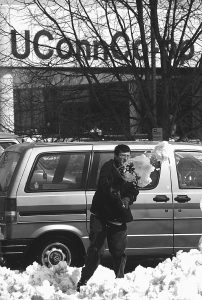 Jason Hall, a senior, shovels out his car on Fairfield Road after a 1997 snowstorm. This was shortly before Fairfield Road was closed to automobile traffic and became Fairfield Way.  (Peter Morenus/UConn File Photo)