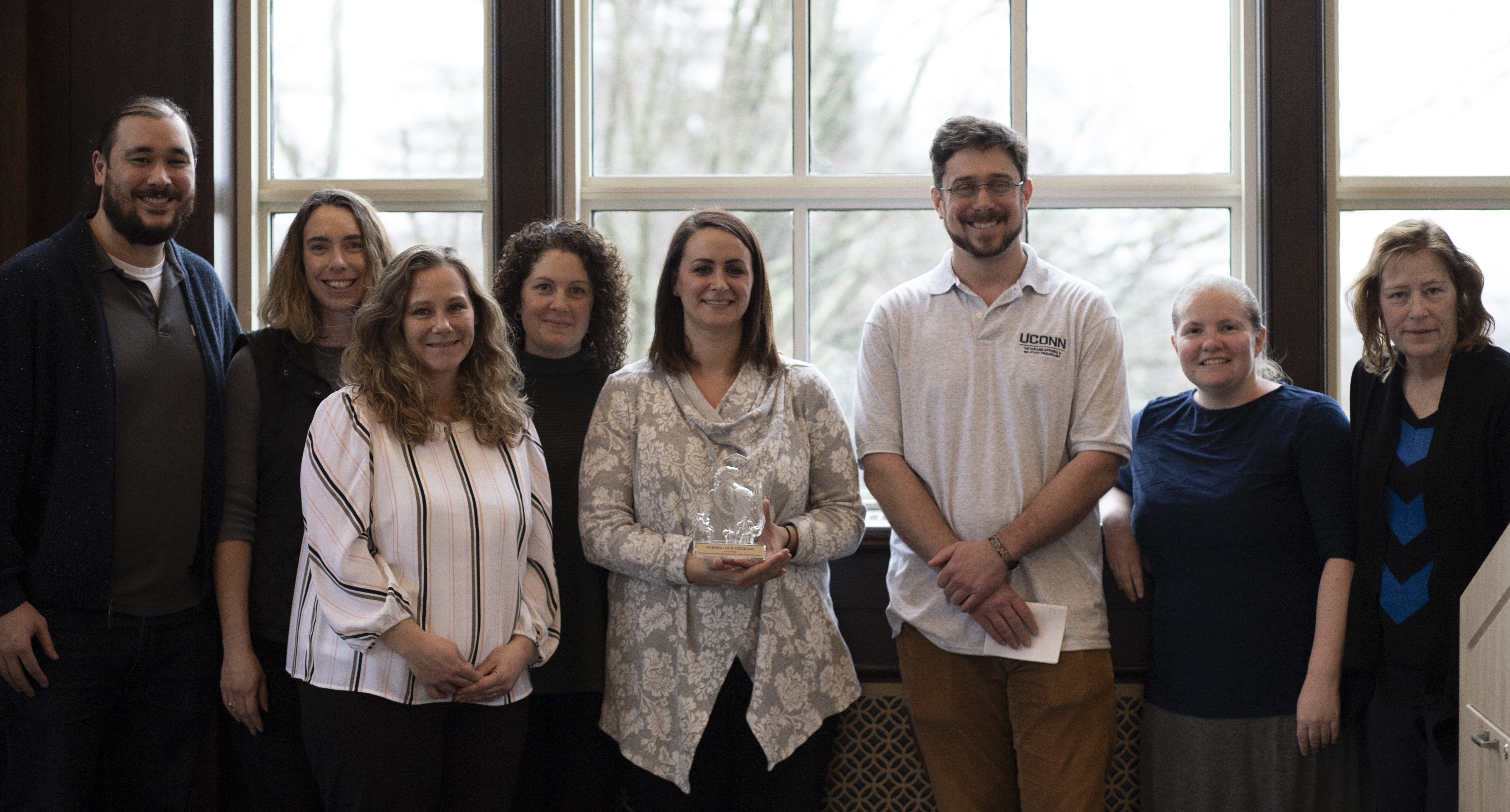 School of Nursing staff accept the trophy for the school’s winning performance in UConn Office of Veterans Affairs and Military Programs’ 7th Annual Homeless Veteran Care Package Drive on February 10, 2020, in the Wilbur Cross North Reading Room.
