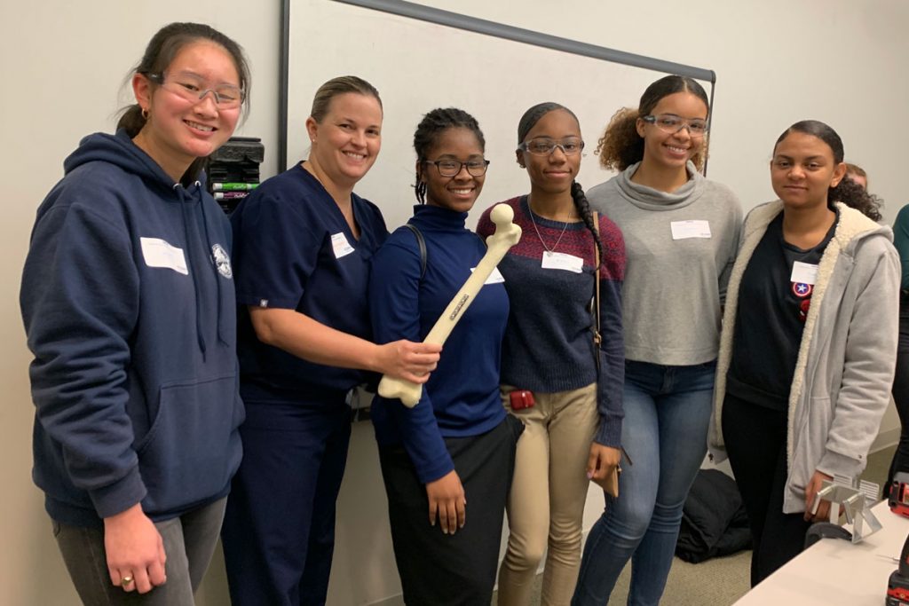 High school students with Dr. Katherine Coyner, who holds a repaired bone model.