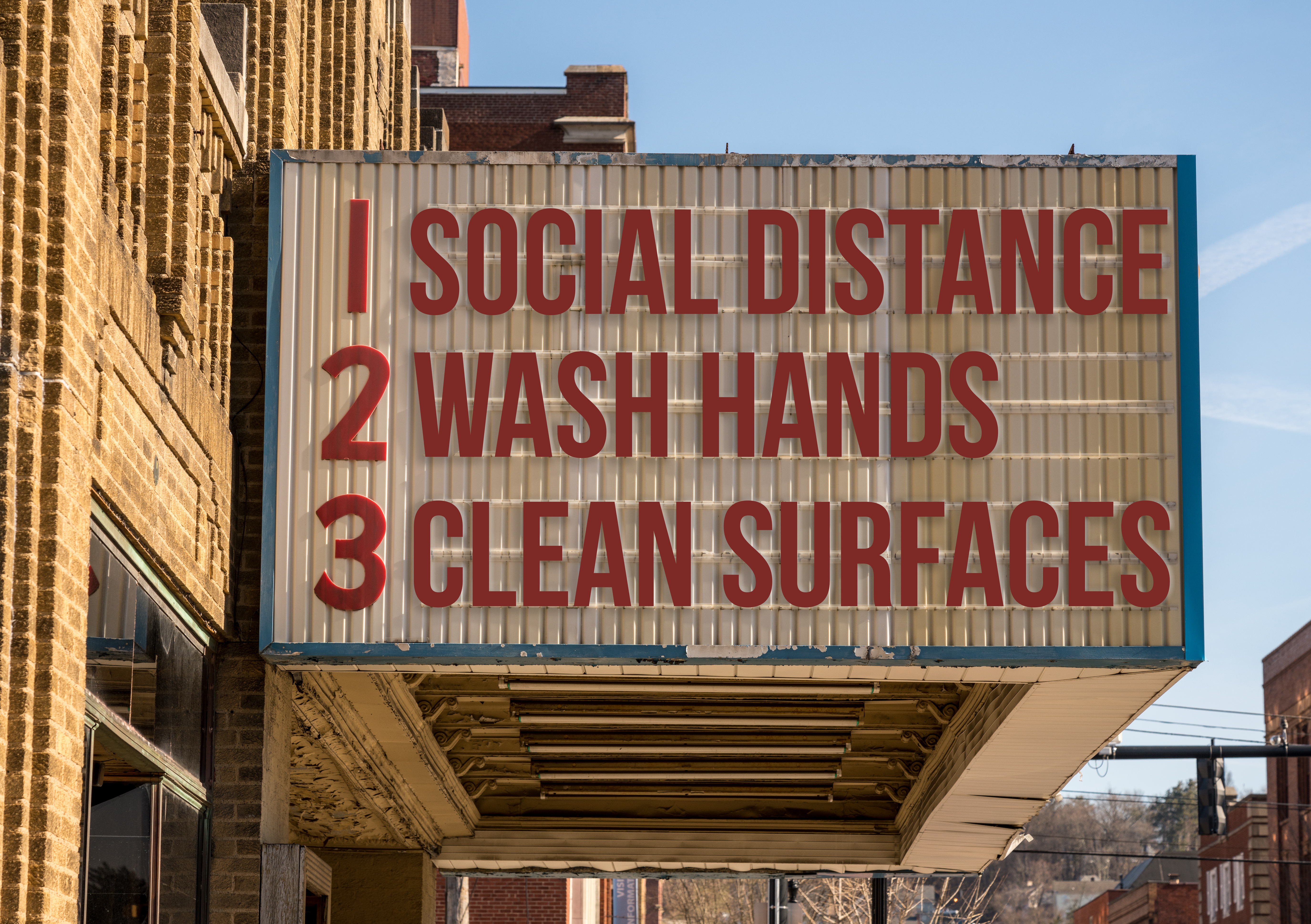 A cinema marquee listing three rules for pandemic safety: social distance, wash hands, and clean surfaces.