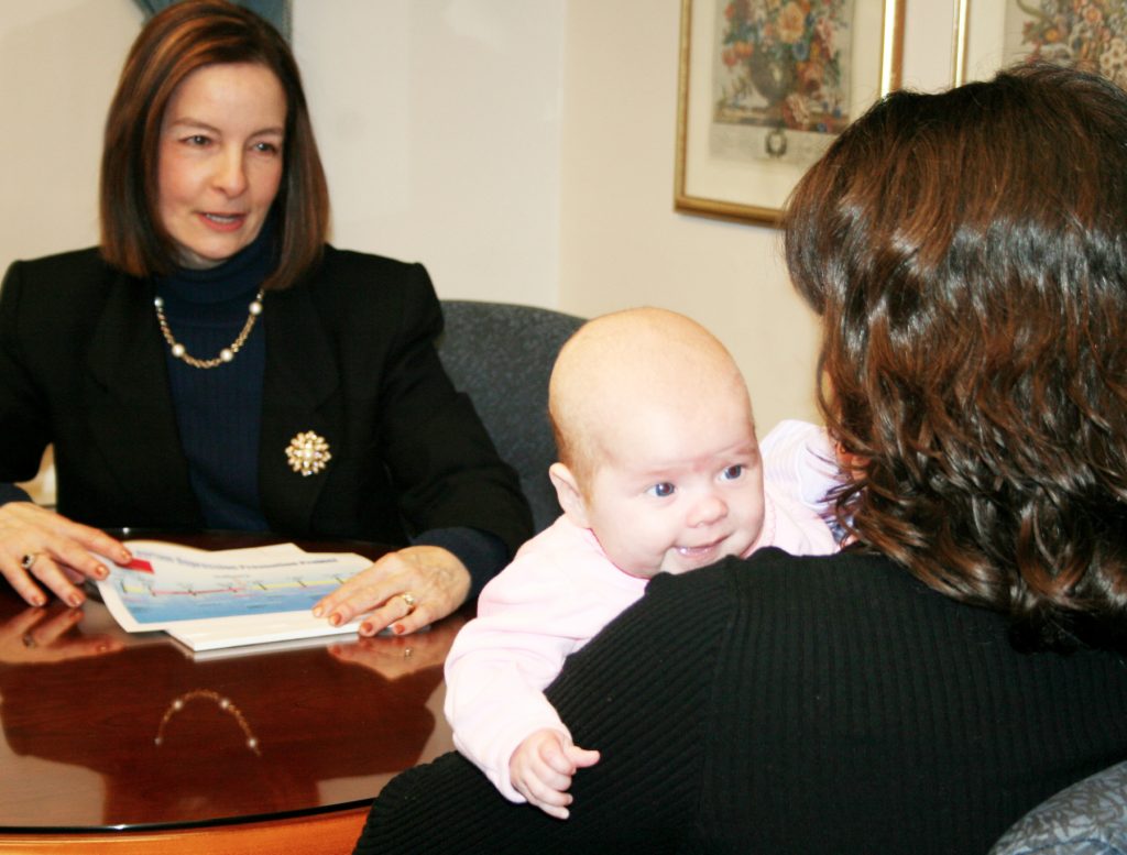 Professor Cheryl Beck meeting with a mother and infant child.