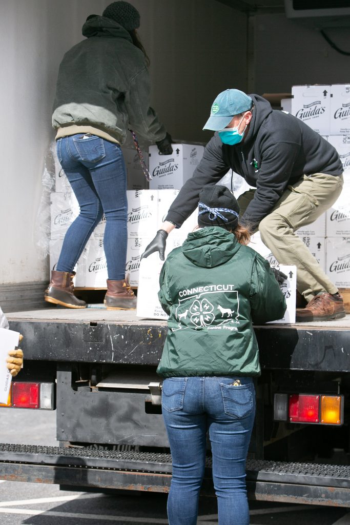 4H volunteers unloading dairy products from the back of a truck.