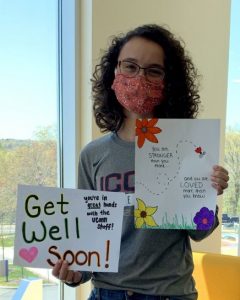 Abby Leander holds a get well soon sign