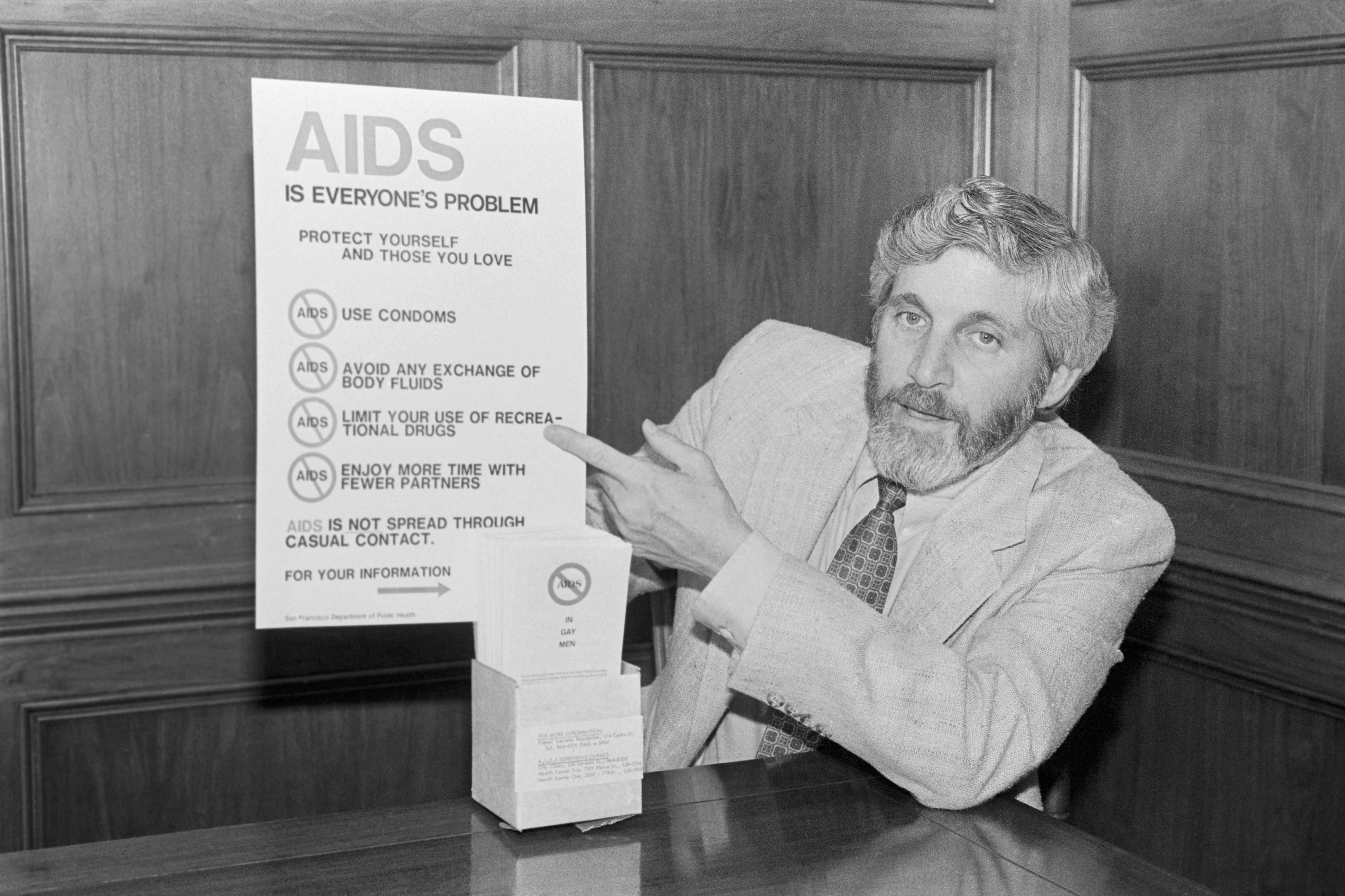 Dr. Mervyn F. Silverman, Director Of Health for the City and County of San Francisco, displays poster and leaflets during the early years of the HIV/AIDS epidemic.