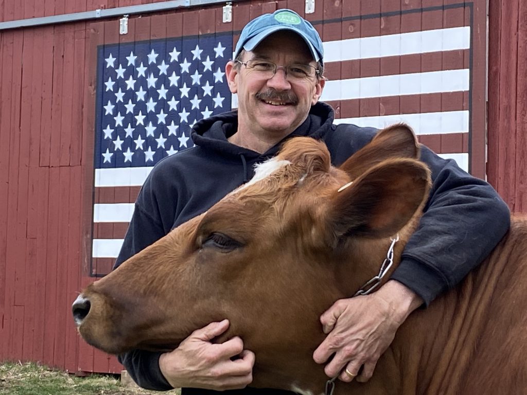 Bill Davenport, UConn Extension educator, embraces a red cow.