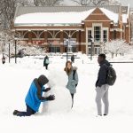 Students building a snowman on the Student Union Mall after a storm storm on March 8, 2018. (Sean Flynn/UConn Photo)