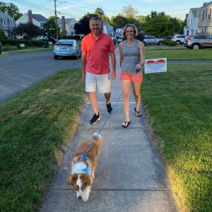 couple walking dog on sidewalk