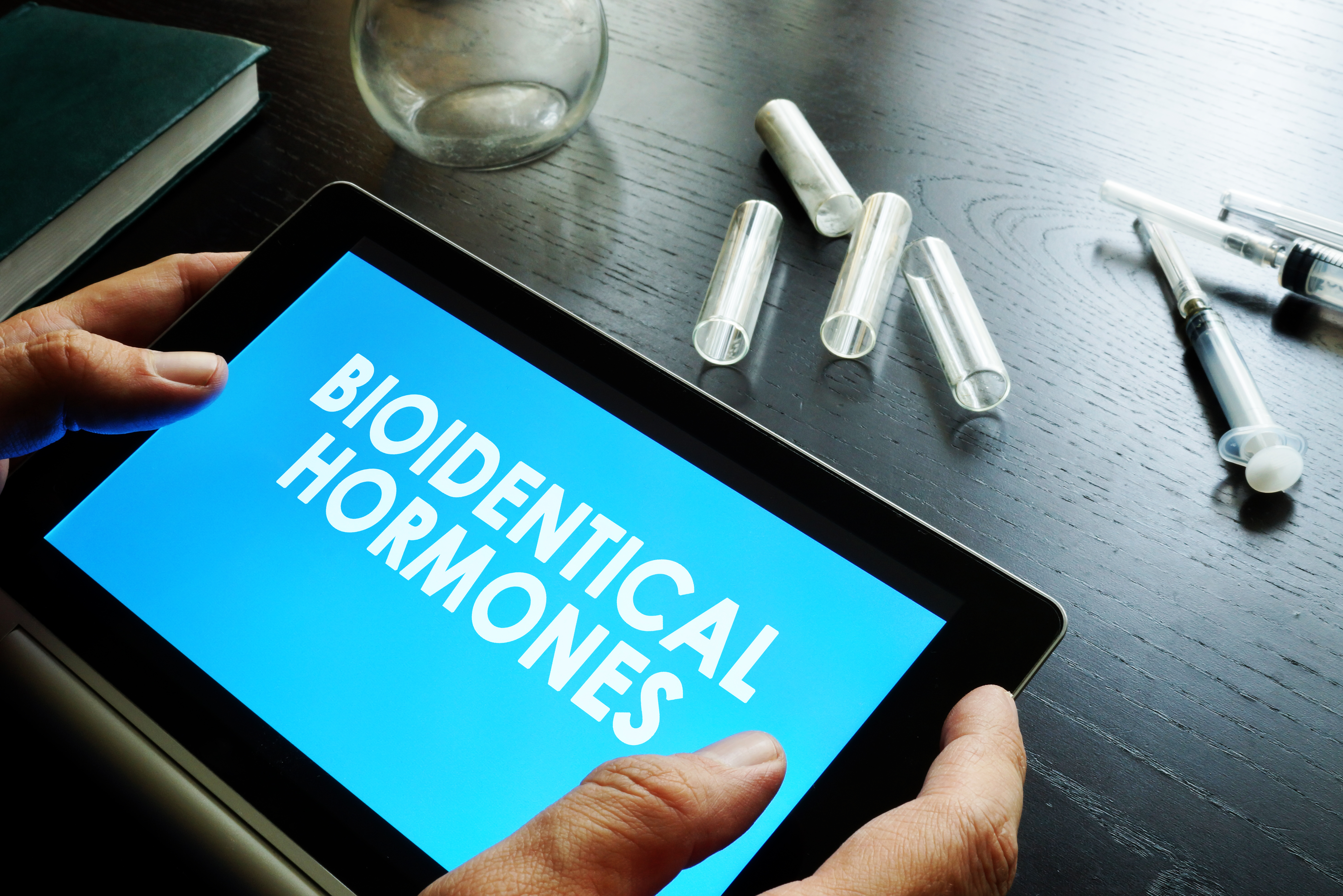 Bioidentical hormones. Doctor holding tablet with sign.