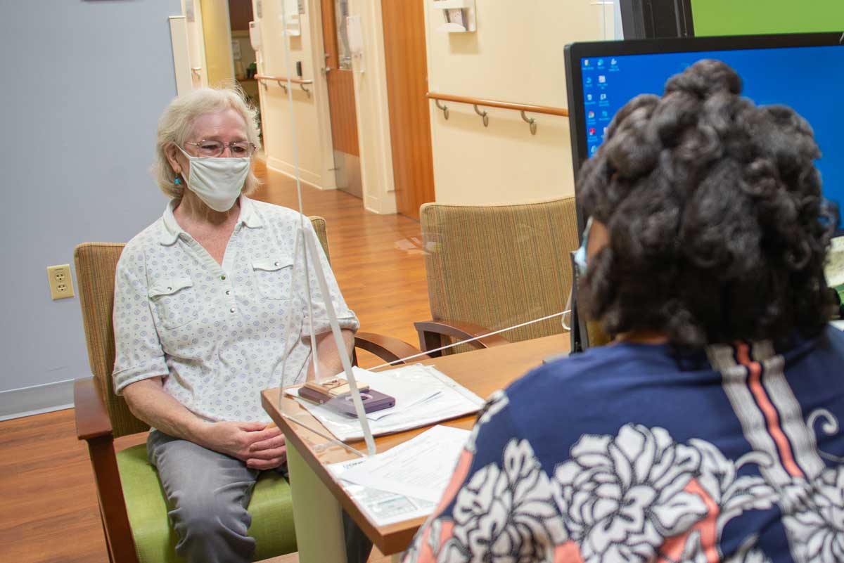 patient and scheduler in masks in the GI clinic