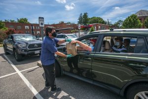 David Hille delivers ice cream to the Criss Family in the parking lot of the UConn Dairy Bar which opened to the public in limited compactly due to the covid 19 epidemic on June 24, 2020. (UConn photo/SeanFlynn)