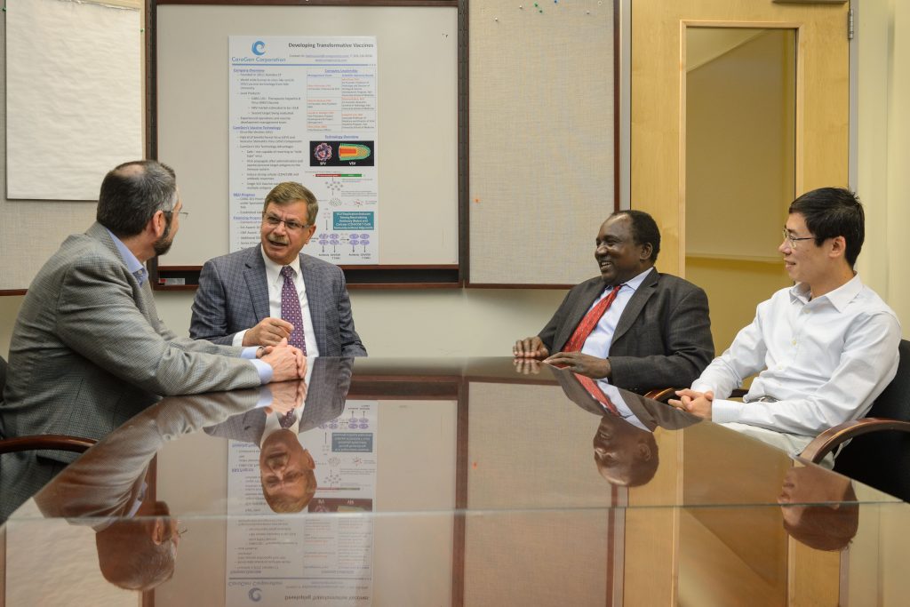 Anthony T. Vella, professor and Boehringer Ingelheim chair in immunology, left, speaks with President and CEO, Bijan Almassian and Valerian Nakaar, vice president for research and development, and Kepeng Wang, assistant professor of immunology at CaroGen Corporation's technology incubation lab in Farmington